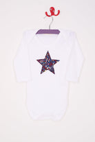 A white bodysuit babygrow with a Liberty Adelajda's Wish print festive star sewn on the front.