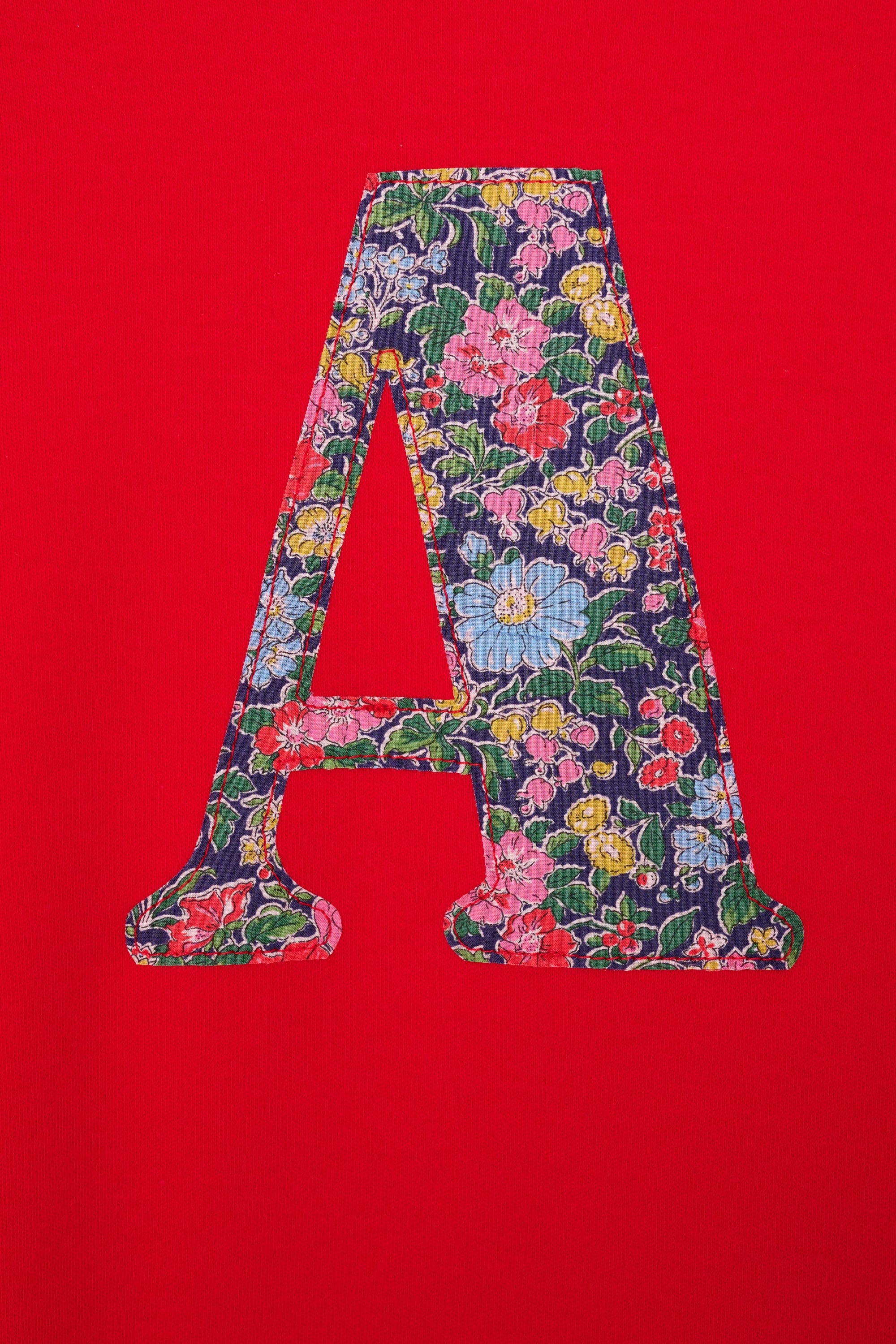 A personalised red cotton t-shirt with an initial on in a Liberty floral fabric.