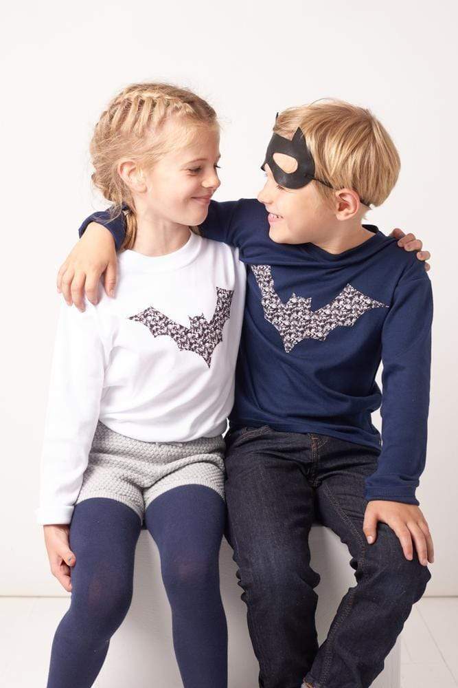 A boy and a girl in white and navy cotton tees with bats on made from Liberty Alba print fabric for halloween.