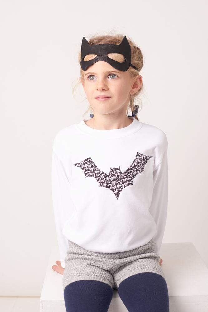 A girl in white  cotton tee with a bat on made from Liberty Alba print fabric for halloween.