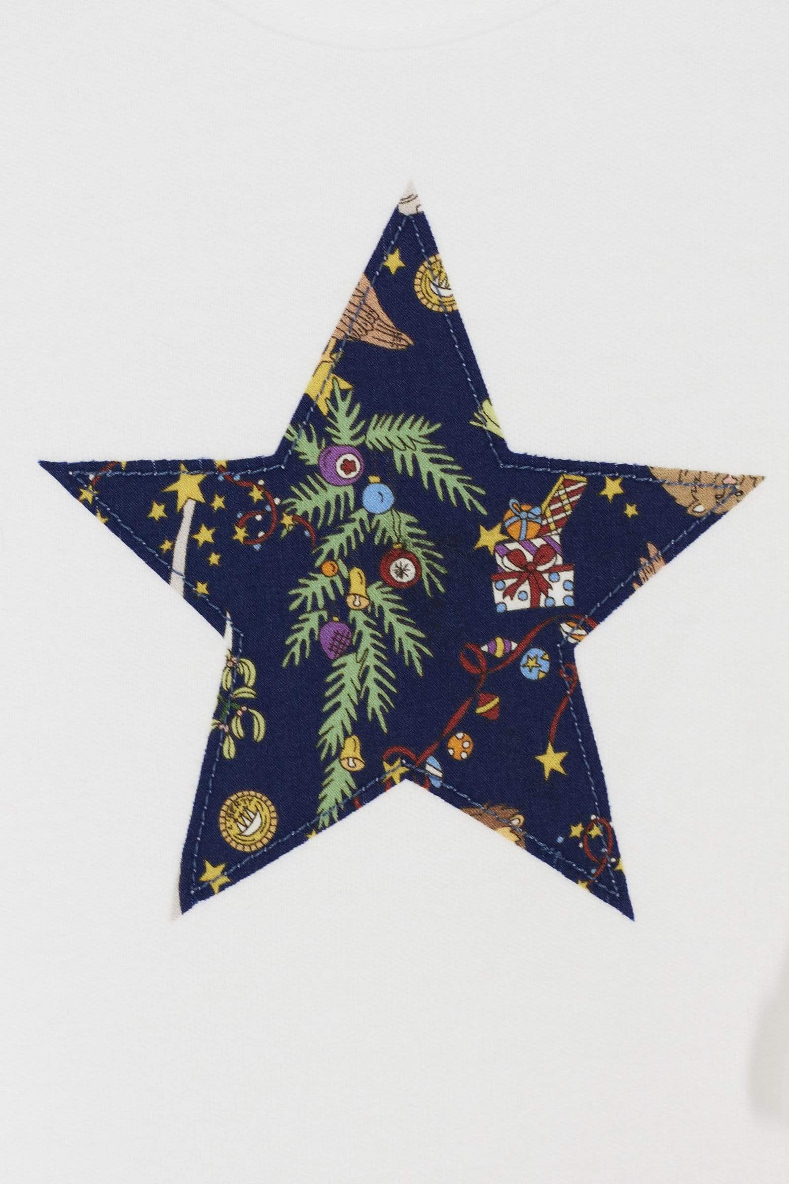 A close up of white bodysuit babygrow with a Liberty Christmas print festive star sewn on the front.