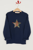 A navy long sleeve christmas t-shirt with a festive star on the front made from Liberty My Little Star print on the front.