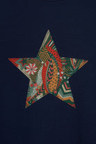 A navy long sleeve christmas t-shirt with a festive star on the front made from Liberty My Little Star print on the front.