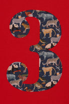 A close up of a red birthday t-shirt with a number 3 on the front made from Liberty zoo print fabric.