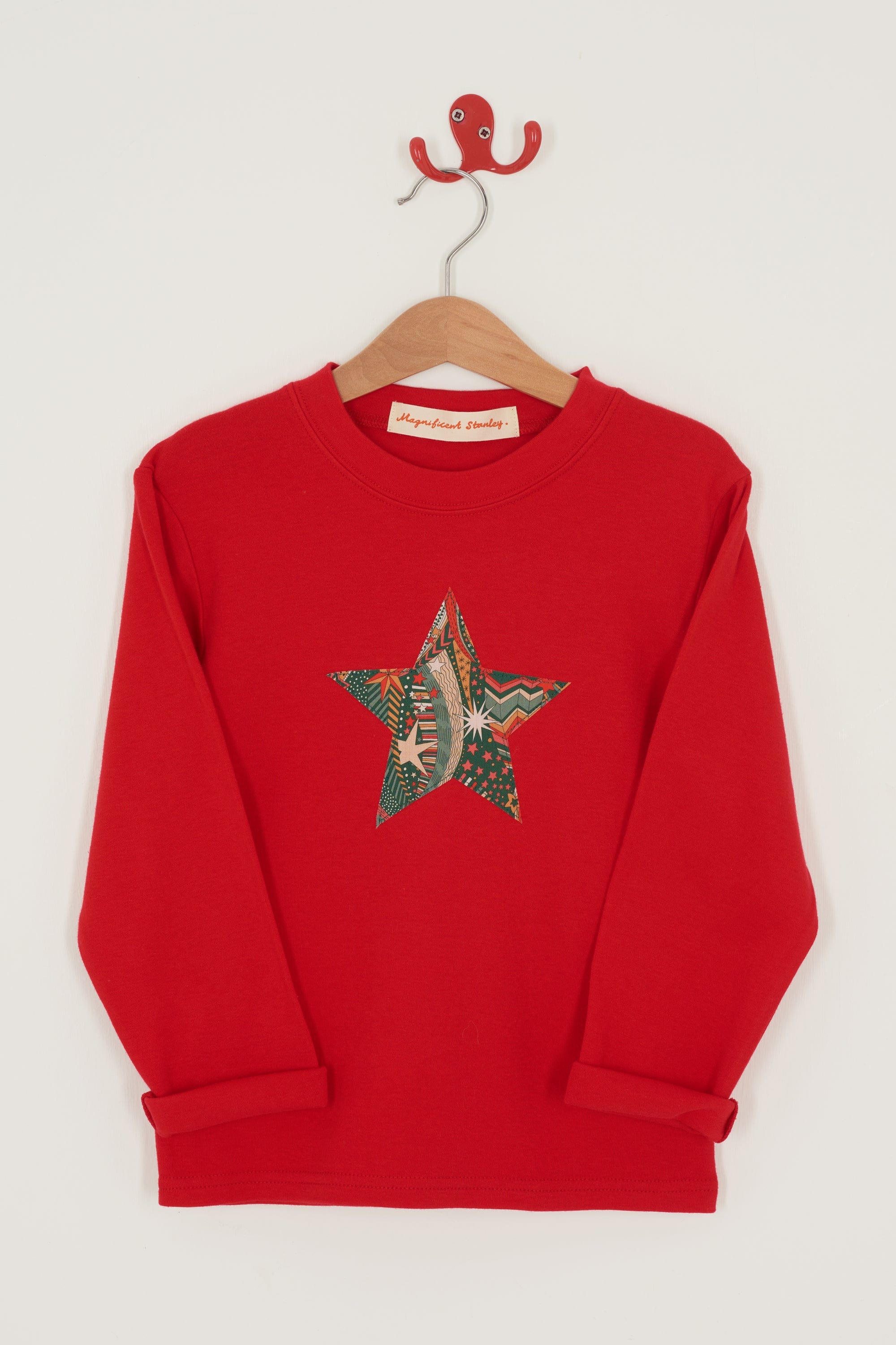 A red Christmas t-shirt with a festive star on the front in a starry Liberty print.