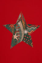 A red Christmas t-shirt with a festive star on the front in a starry Liberty print.