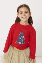 A smiling 5 year old girl wearing a festive red t-shirt with a christmas tree on the front made from Liberty Christmas fabric.